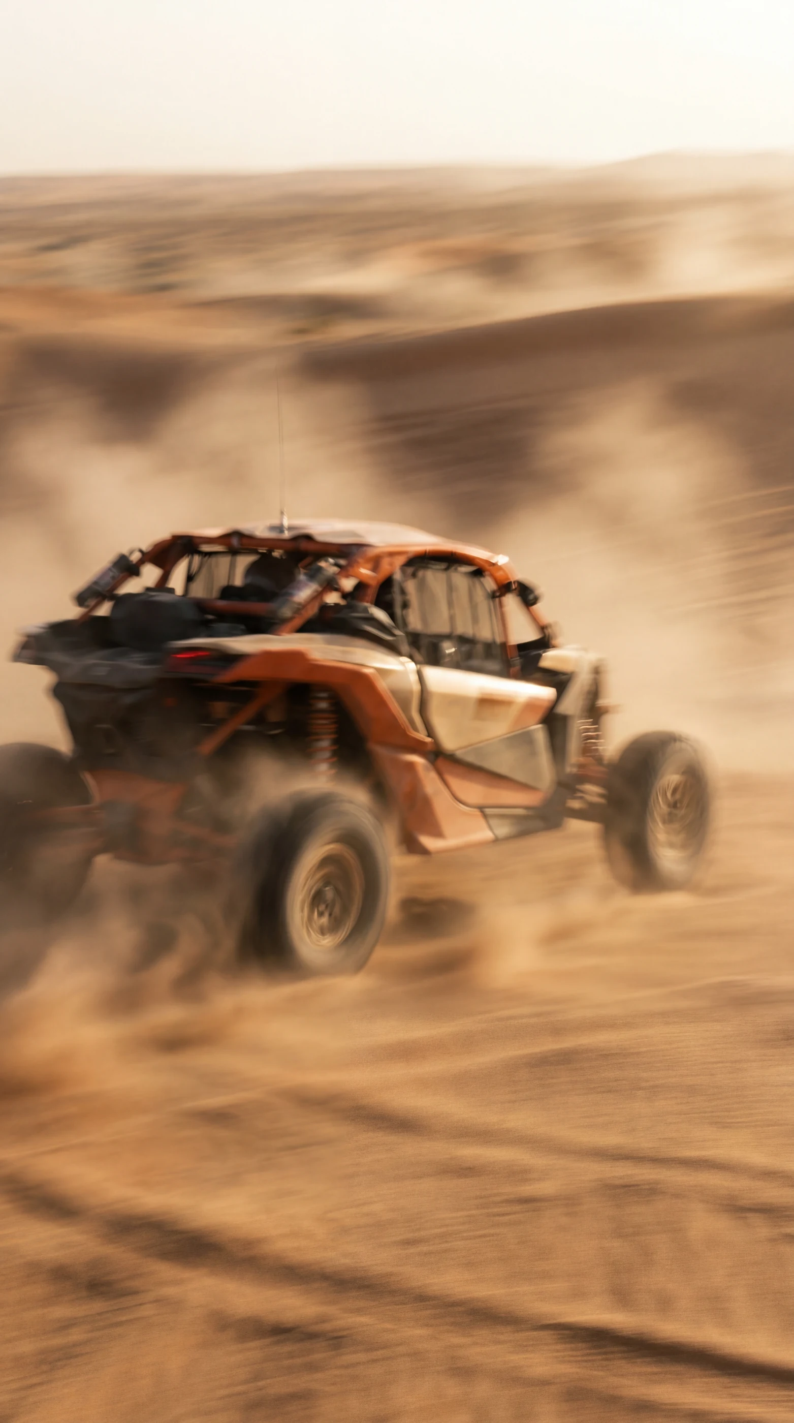 Buggy levantando uma cortina de poeira sobre as dunas do interior.
